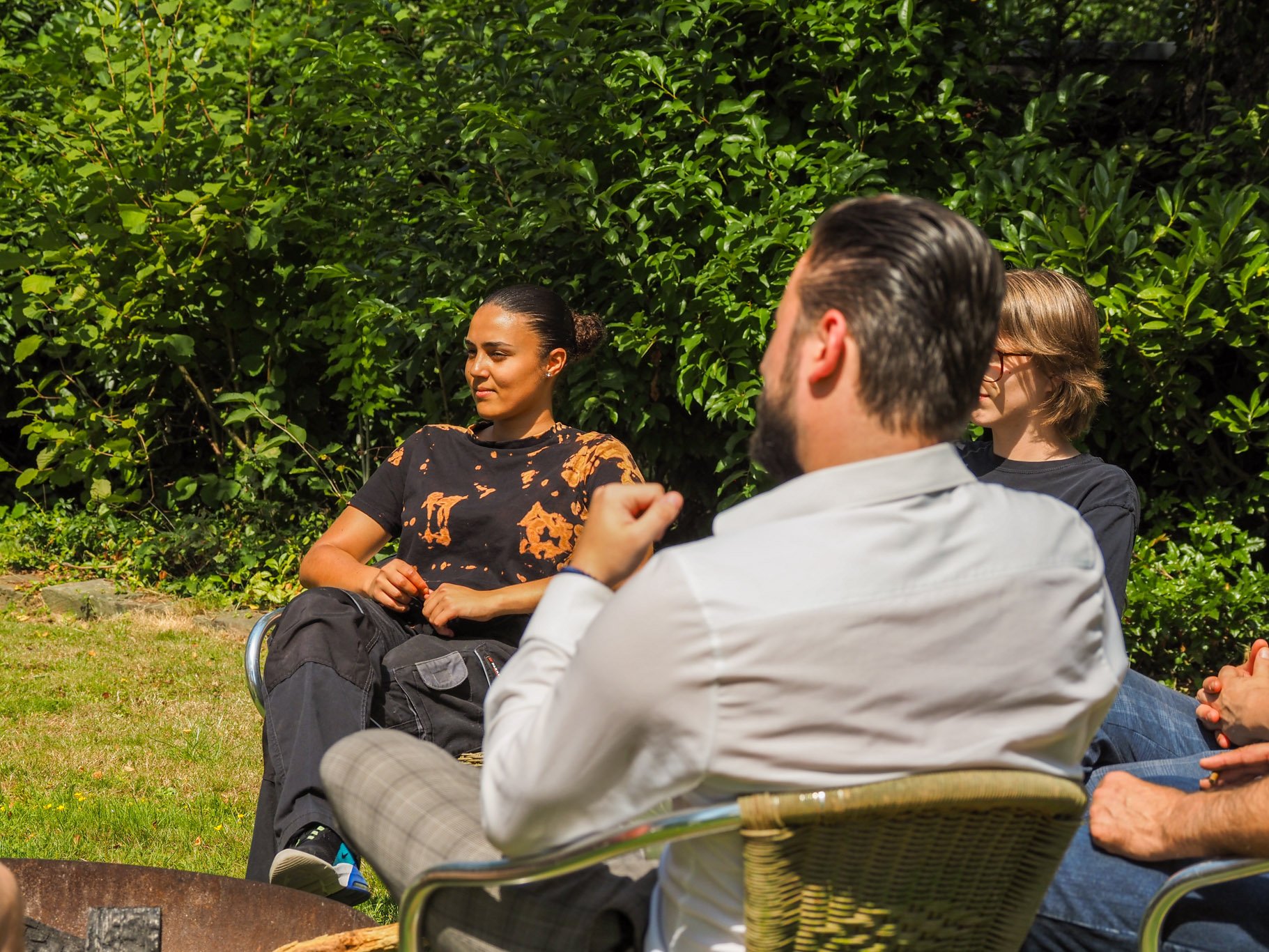 Groepsdiscussie in een groene tuin.